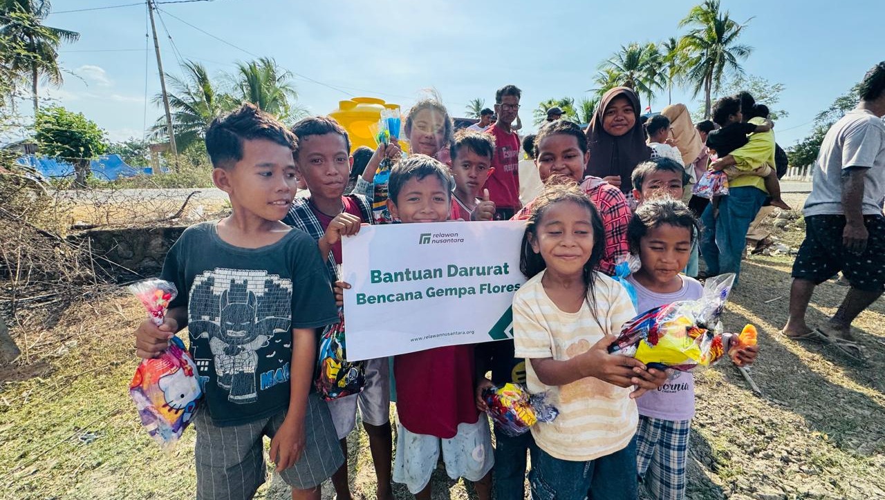Anak-anak penyintas bencana bergembira saat menerima paket bantuan darurat dari relawan.