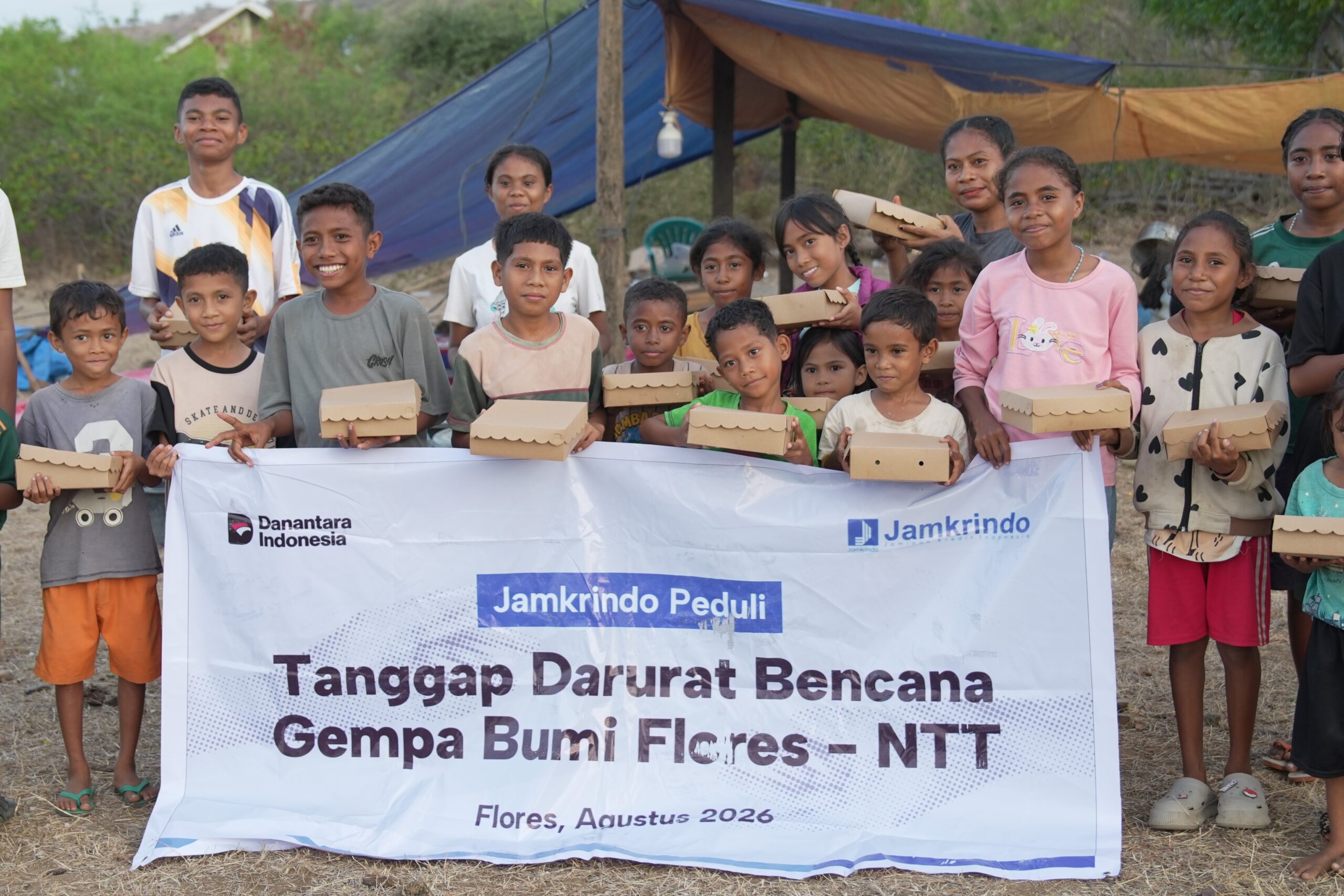 Penyintas gempa Flores di Nagekeo foto bersama membawa paket makanan siap saji dengan spanduk Jamkrindo Peduli dan Relawan Nusantara.