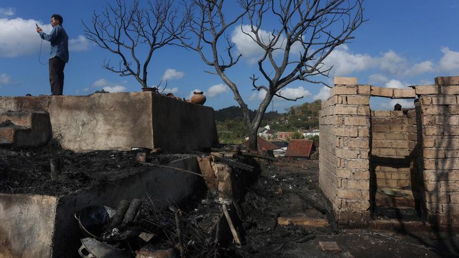 Warga berdiri di atas reruntuhan rumah adat Sade yang hangus akibat kebakaran di Lombok Tengah