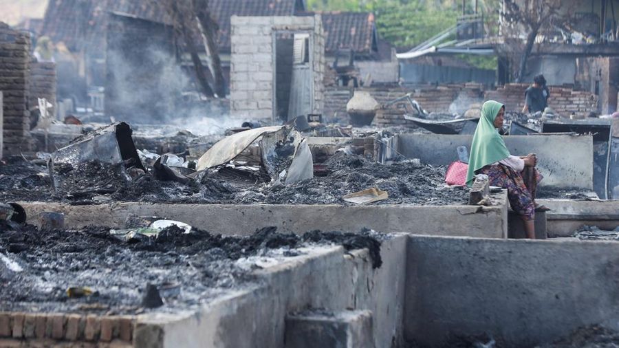 Warga Desa Adat Sade duduk termenung di antara puing rumahnya usai kebakaran hebat di Lombok Tengah