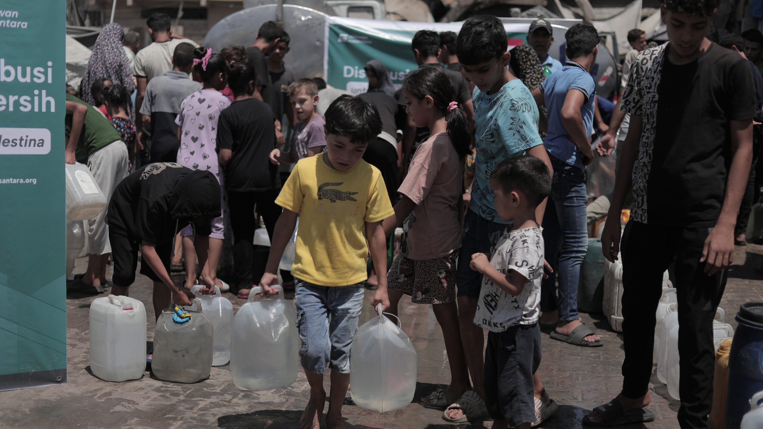 Anak-anak di Gaza mengangkut galon dan jerigen bantuan air bersih Relawan Nusantara.