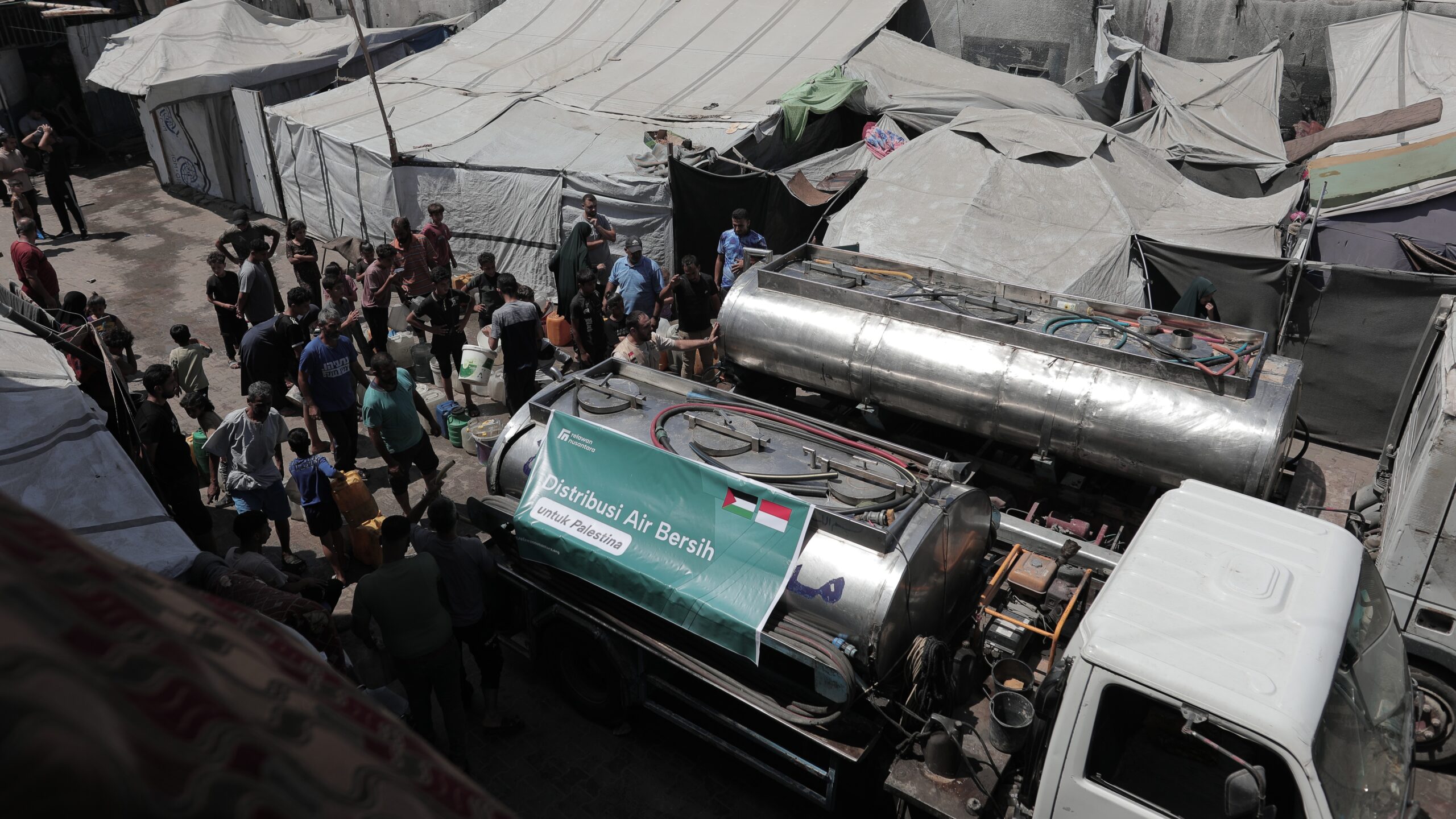 Truk tangki distribusi air bersih Relawan Nusantara melayani warga di kamp pengungsian Gaza.