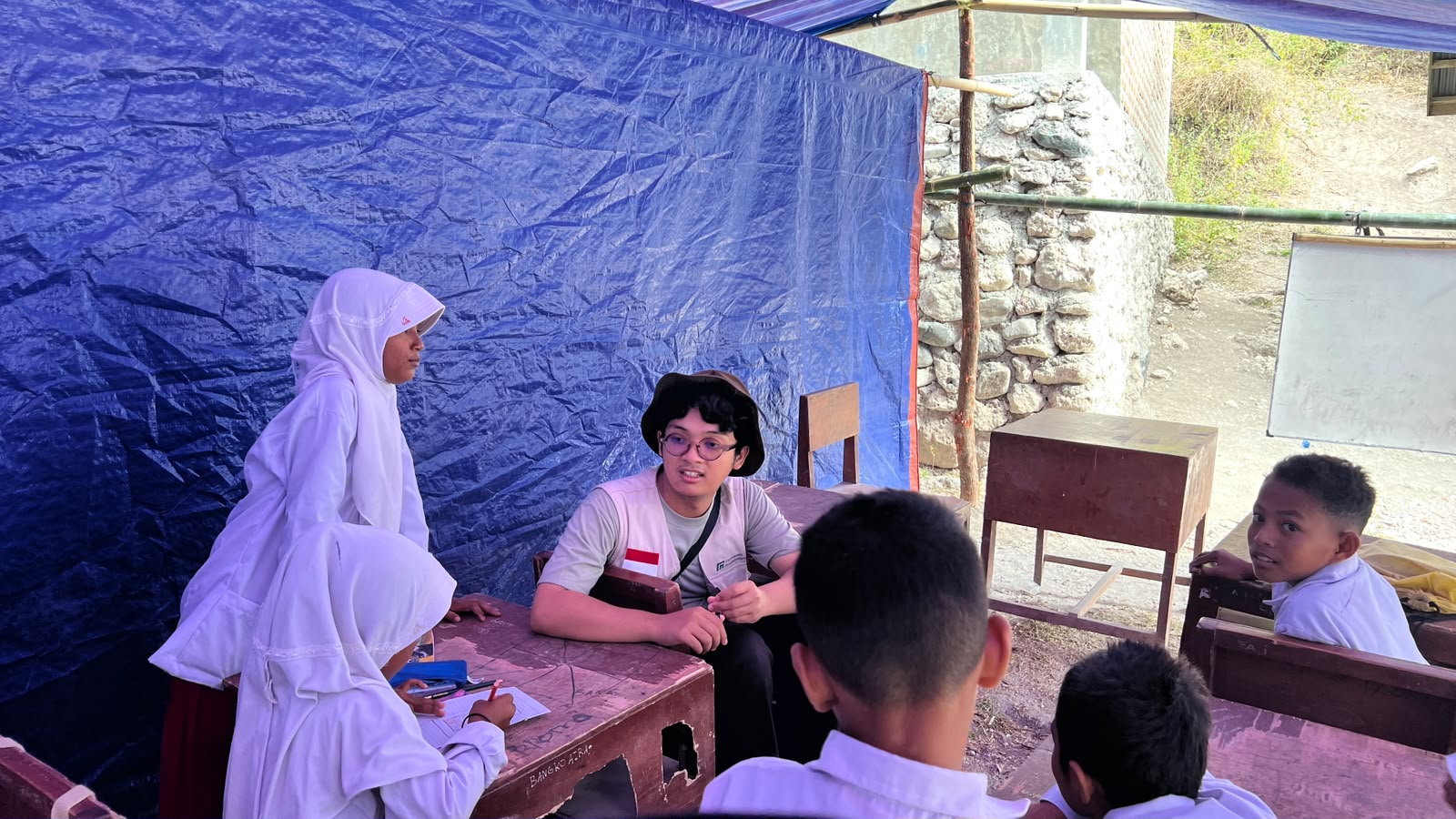 Siswa MIS Mujahidin Arabi mengikuti kegiatan belajar mengajar di dalam kelas darurat beratap tenda.