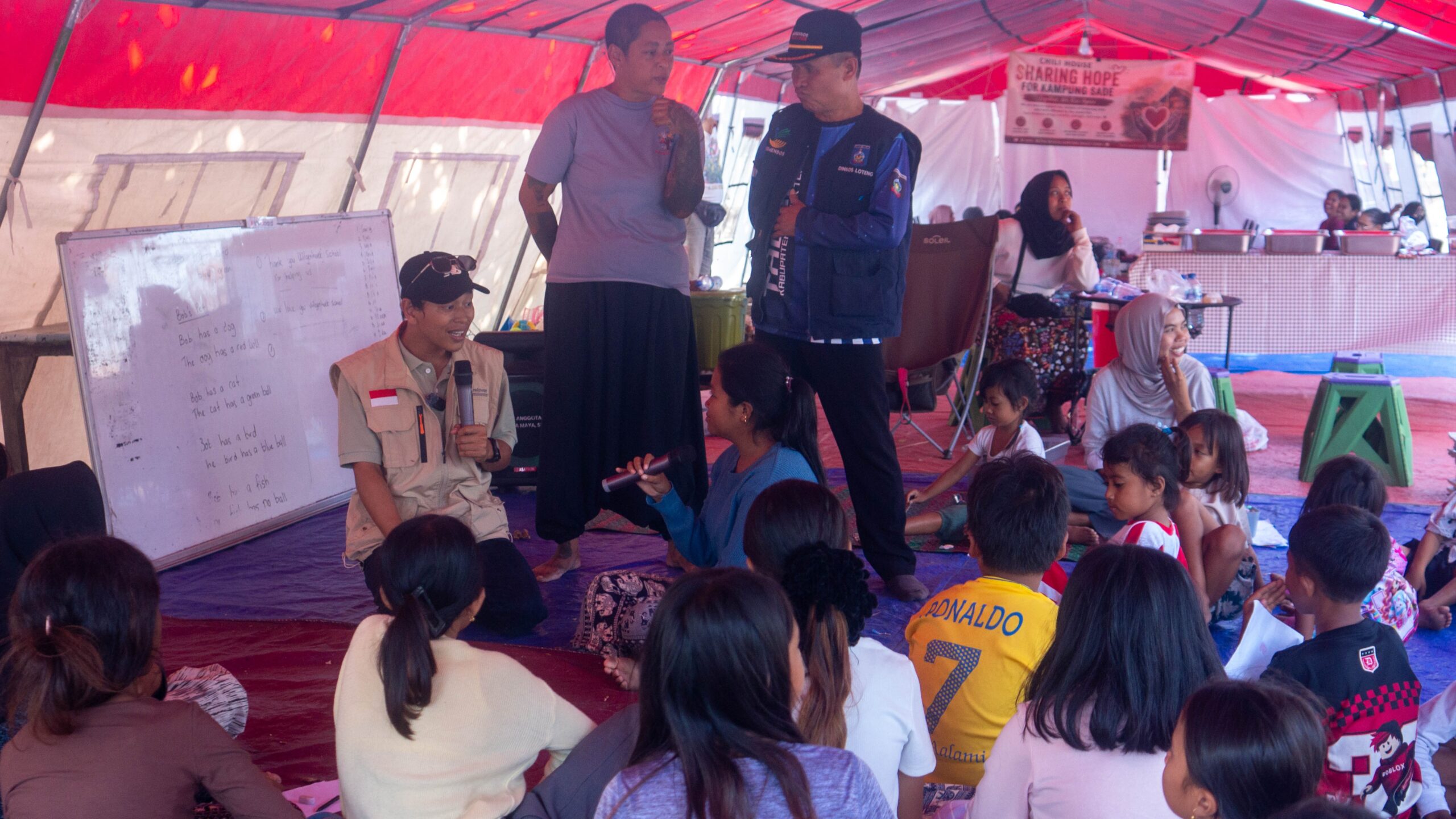 Tim Relawan Nusantara sedang berdialog dan berinteraksi dengan anak-anak serta warga penyintas kebakaran di dalam tenda pengungsian Desa Sade.