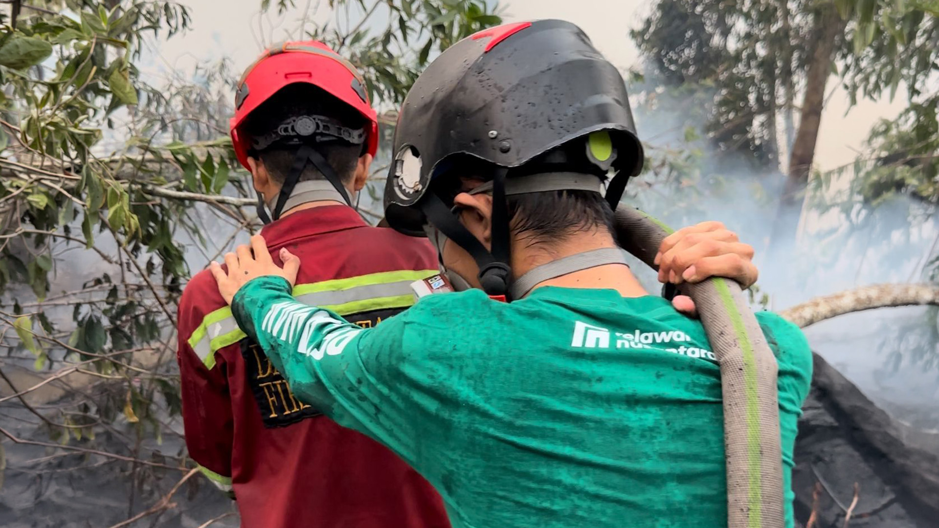 Anggota Relawan Nusantara mengarahkan selang air untuk pendinginan lahan terbakar di Pontianak.