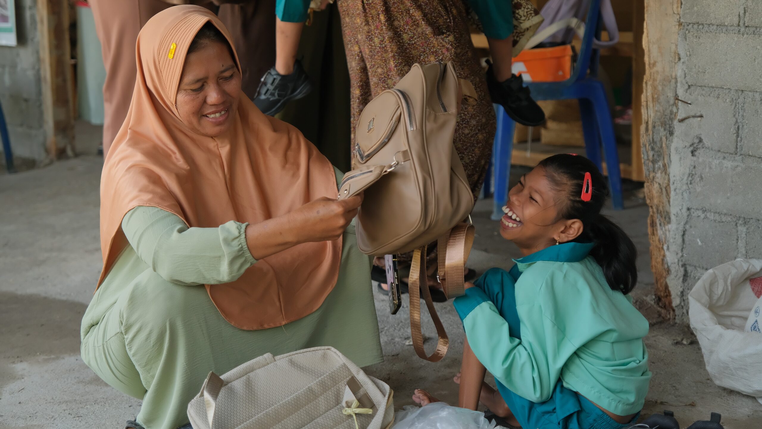 Kebahagiaan siswa disabilitas dan orang tua saat menerima bantuan tas sekolah baru di SLB Cahaya Prestasi.