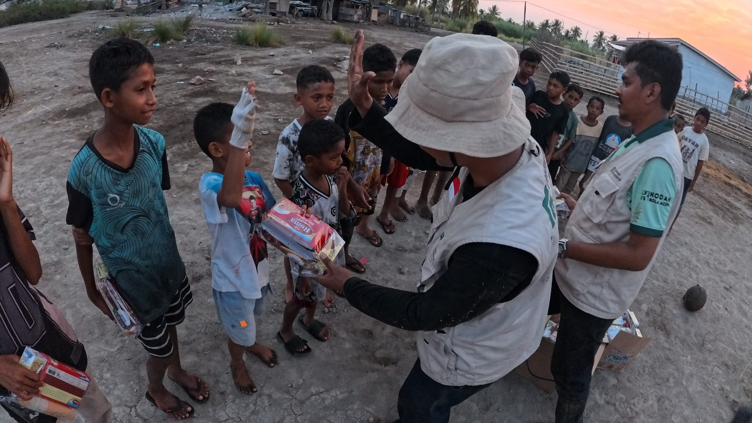 Relawan Nusantara menyerahkan biskuit Pemberian Makanan Tambahan PMT kepada anak-anak di Desa Marapokot Nagekeo.
