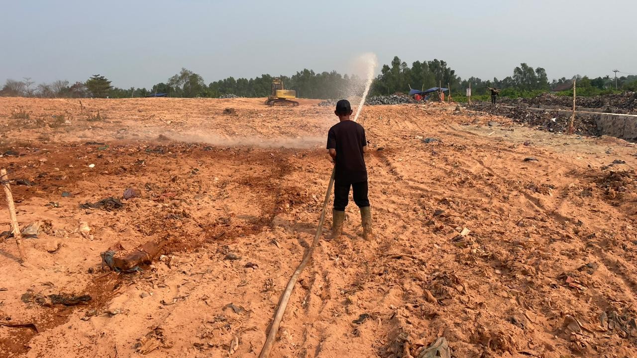 Aksi penyiraman lahan menggunakan selang air dalam program penghijauan eks-TPA Basirih Banjarmasin.