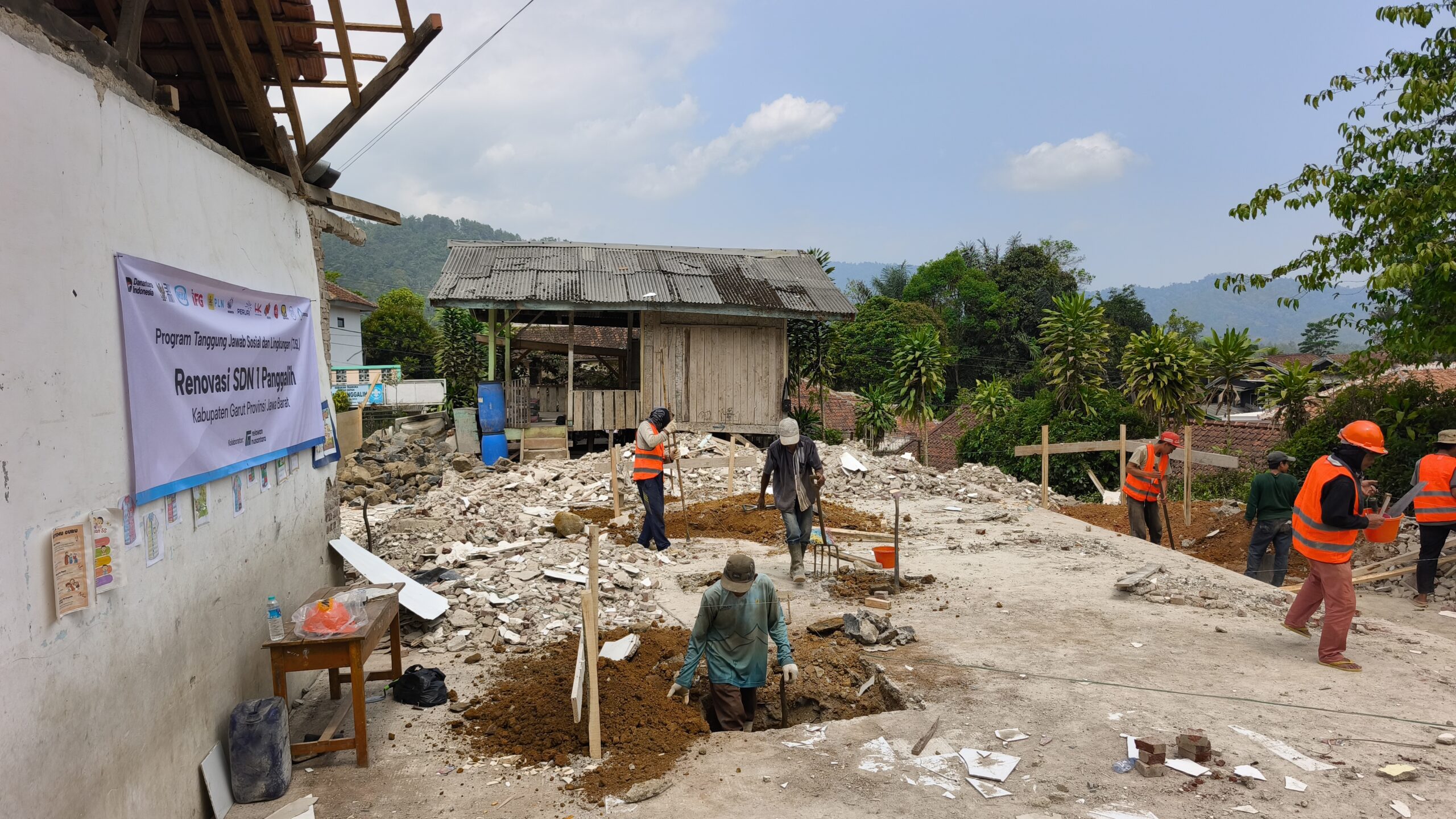 Para pekerja konstruksi dan relawan sedang melakukan pengerjaan pembongkaran dan renovasi SDN 1 Panggalih.