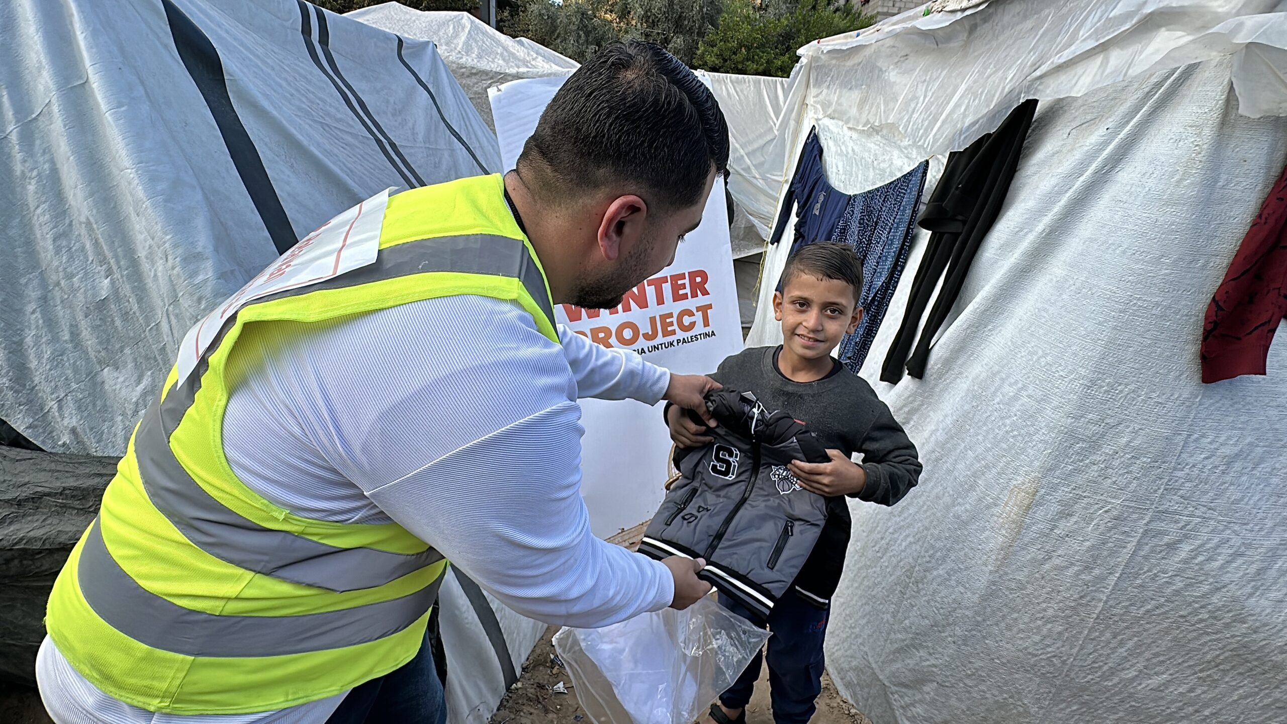 Relawan menyalurkan bantuan jaket musim dingin Palestina kepada anak di pengungsian Gaza.