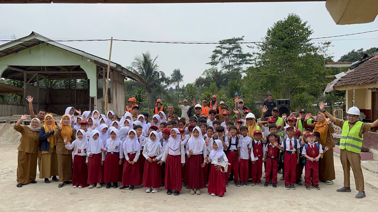 Siswa-siswi dan para guru SDN 1 Panggalih Garut melambaikan tangan bersama tim proyek renovasi BUMN.